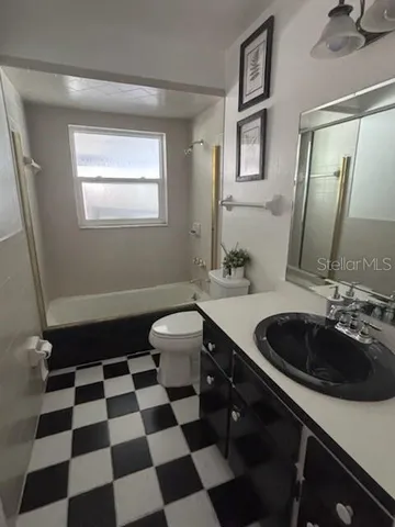 a bathroom with a sink a toilet a mirror and shower