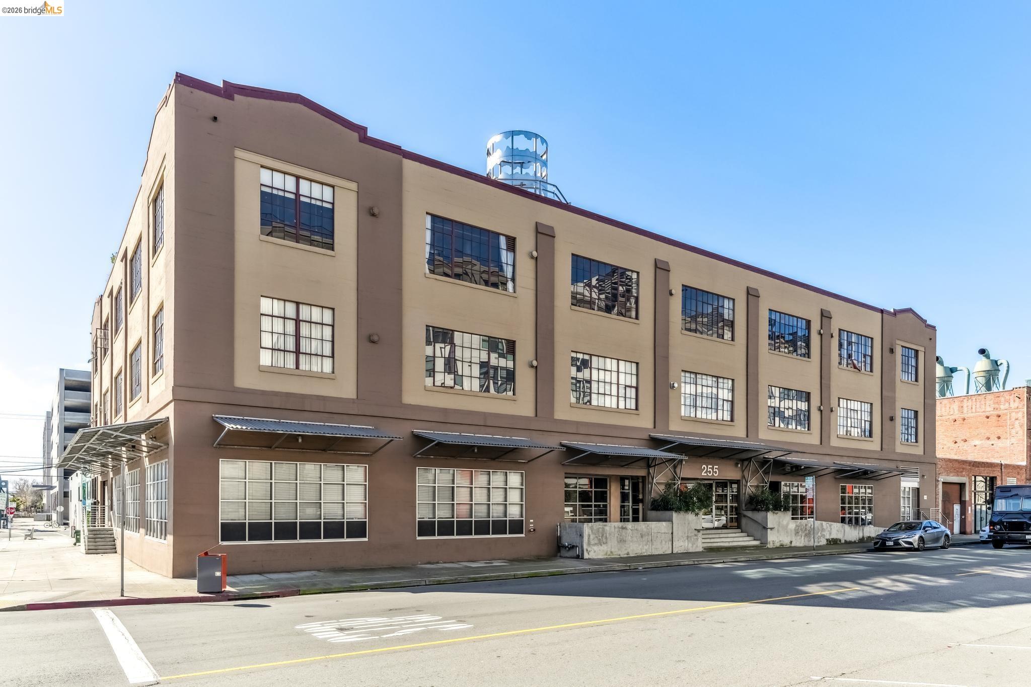 255 3rd Street, Unit 206 Oakland, CA 94607 - Photo 7 of 7 Three-story commercial building featuring a beige and brown facade with prominent grid-pattern windows