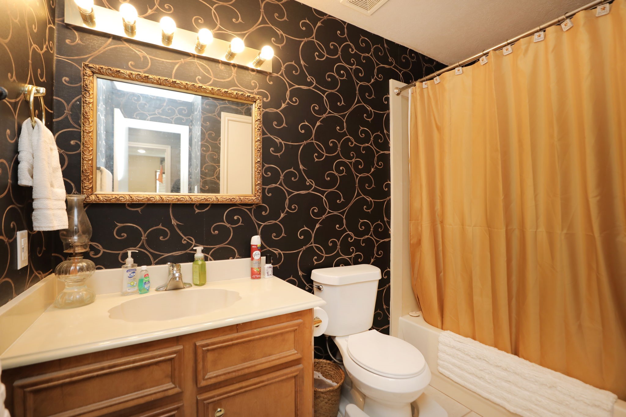 9810 Sugar Tree Court Houston, TX 77070 - Photo 20 of 30 a bathroom with a sink a toilet a mirror and shower curtain