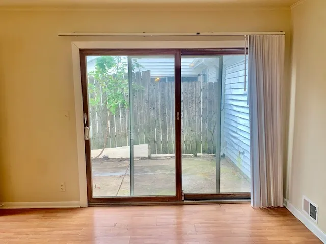 a view of a room with wooden floor and door