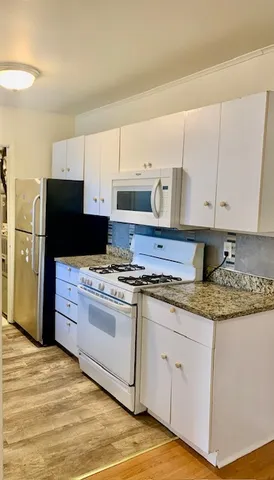 a kitchen with stainless steel appliances granite countertop a stove a sink and a refrigerator