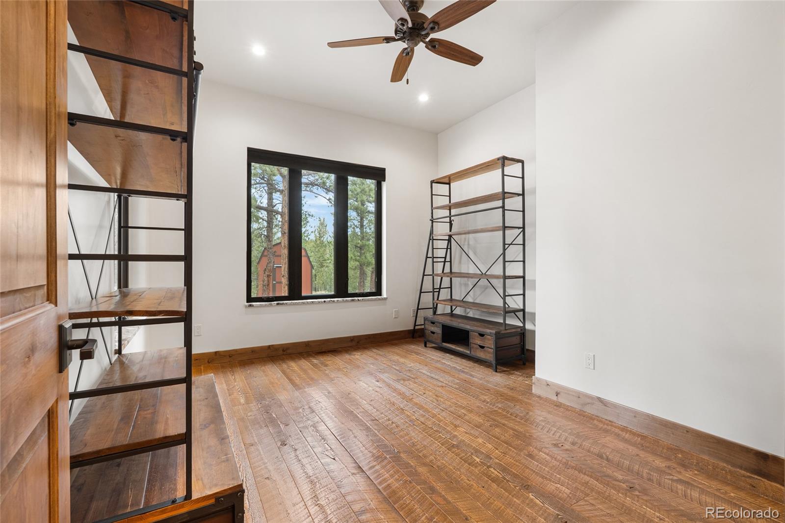 280 Double Tree Road Bailey, CO 80421 - Photo 18 of 43 an empty room with wooden floor and windows
