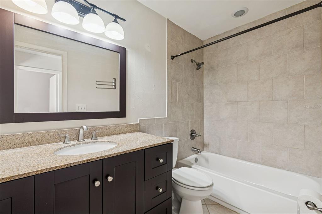 Undisclosed Address Temple Terrace, FL 33617 - Photo 15 of 23 a bathroom with a granite countertop bathtub sink mirror and toilet