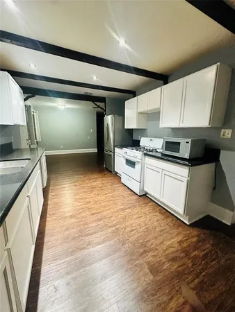 a kitchen with stainless steel appliances granite countertop a sink a stove top oven a counter space and cabinets