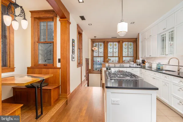 a kitchen with stainless steel appliances granite countertop a refrigerator a stove a sink dishwasher and white cabinets with wooden floor