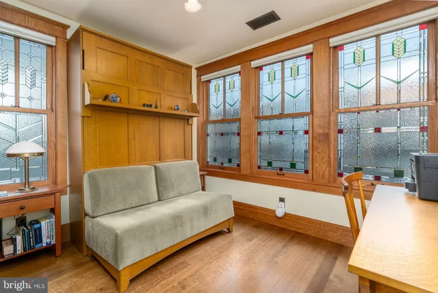a living room with furniture a flat screen tv and a floor to ceiling window