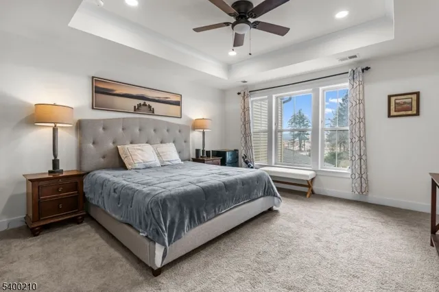 a spacious bedroom with a bed and a chandelier