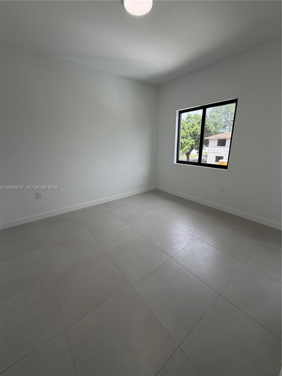 8034 Northwest 14th Place, Unit 8034 Miami, FL 33147 - Photo 13 of 14 an empty room with windows