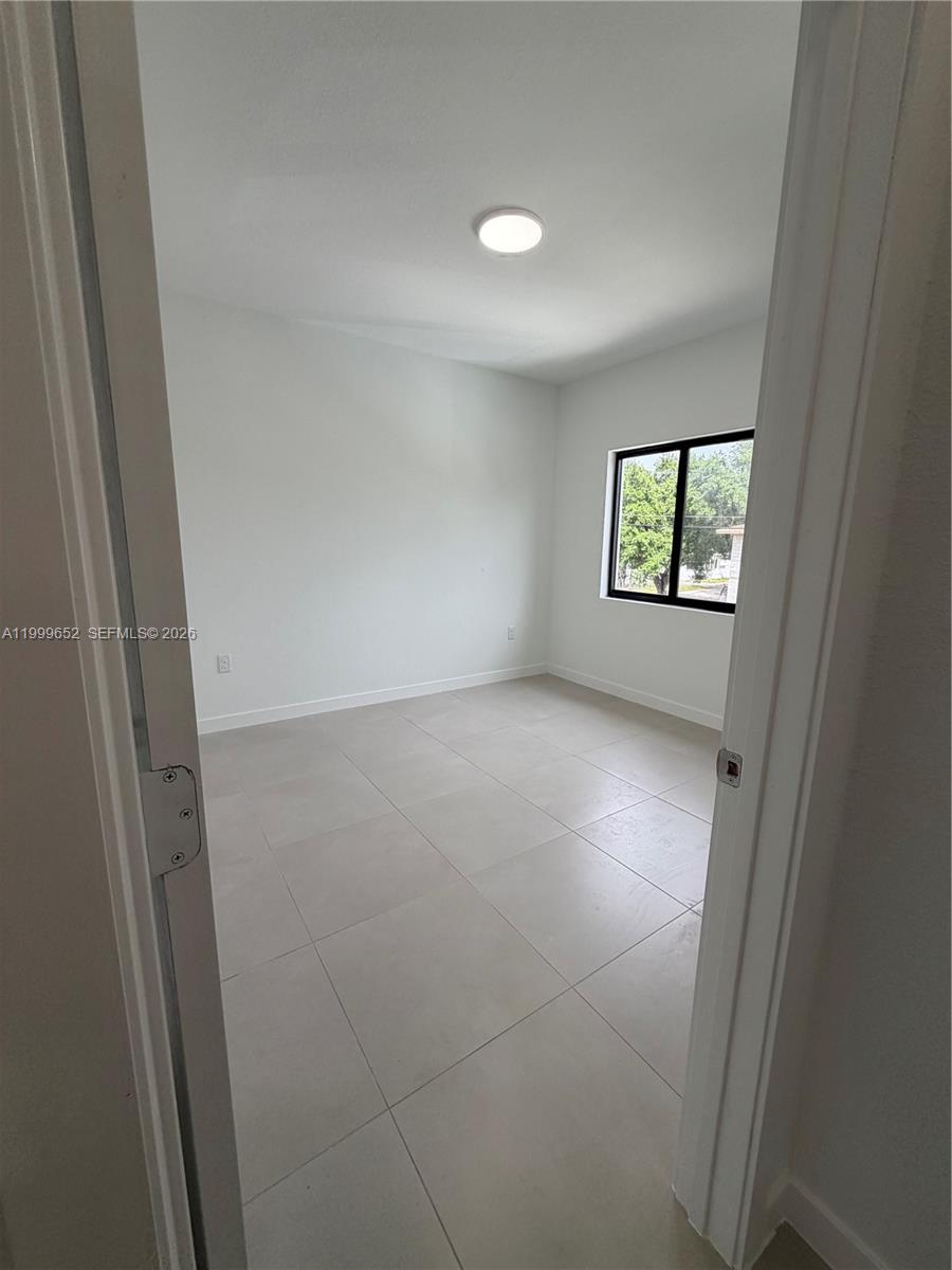 8034 Northwest 14th Place, Unit 8034 Miami, FL 33147 - Photo 14 of 14 an empty room with windows and door