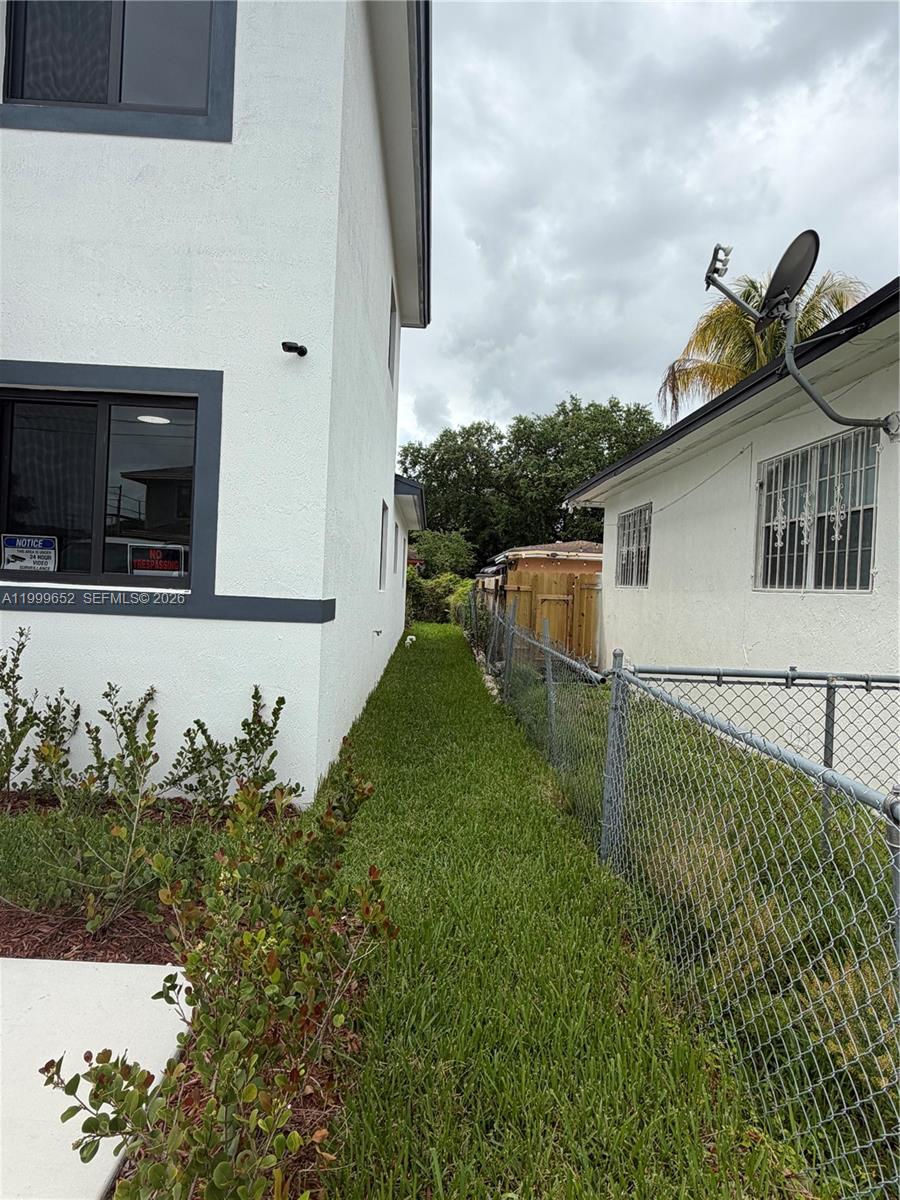 8034 Northwest 14th Place, Unit 8034 Miami, FL 33147 - Photo 2 of 14 a backyard of a house with table and chairs