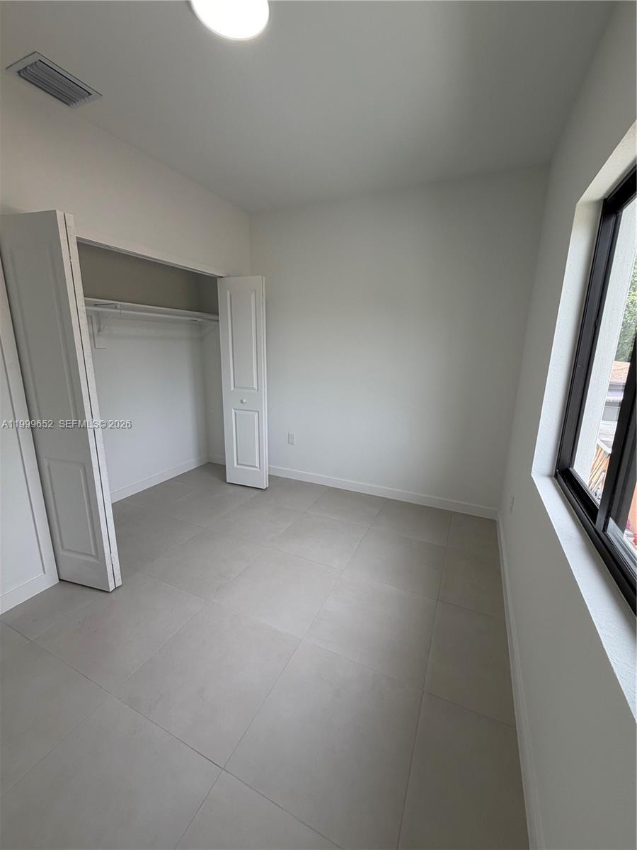 8034 Northwest 14th Place, Unit 8034 Miami, FL 33147 - Photo 8 of 14 an empty room with a fireplace