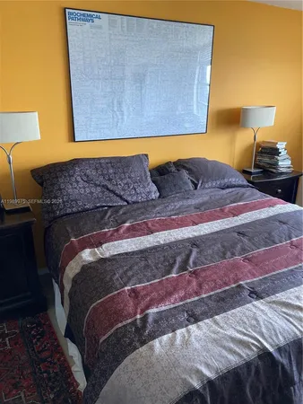 a bed sitting in a bedroom next to a lamp