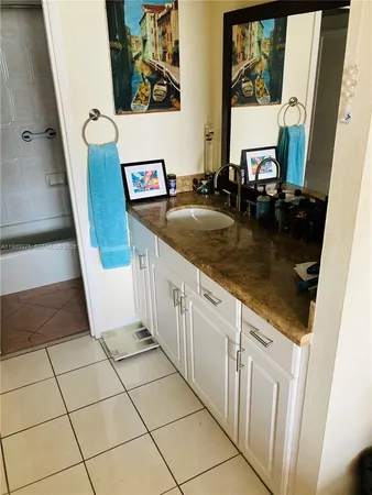 a kitchen with granite countertop a sink a stove a microwave and cabinets