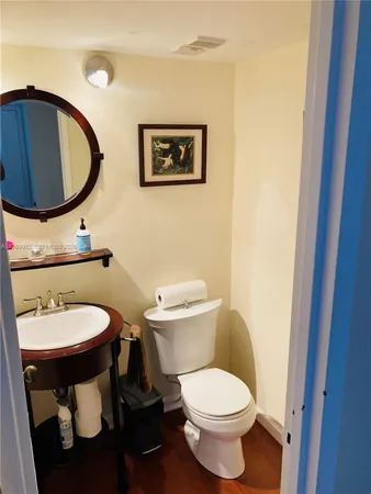 a bathroom with a toilet a sink and a mirror