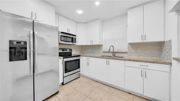 a kitchen with stainless steel appliances granite countertop a refrigerator stove and sink