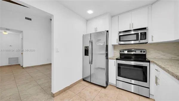 a kitchen with cabinets stainless steel appliances and sink