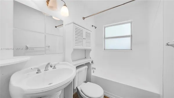 a bathroom with a sink toilet and mirror