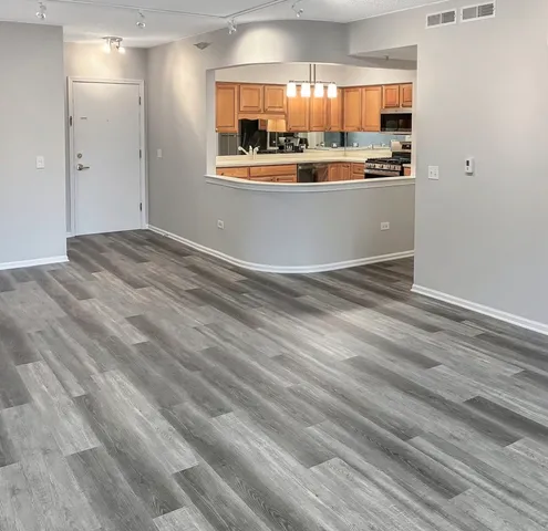 a view of kitchen with stainless steel appliances granite countertop white cabinets and window
