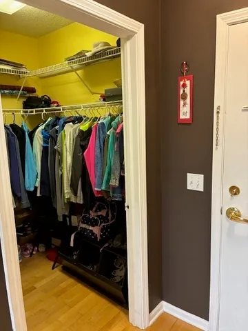 a view of walk in closet with clothes and shoes