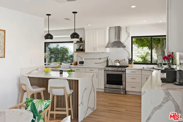 a kitchen with a stove a refrigerator and a wooden floor