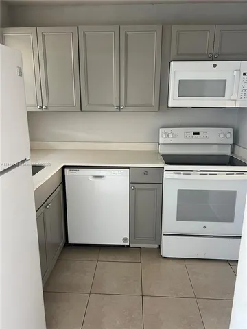 a stove top oven sitting inside of a kitchen with white cabinets