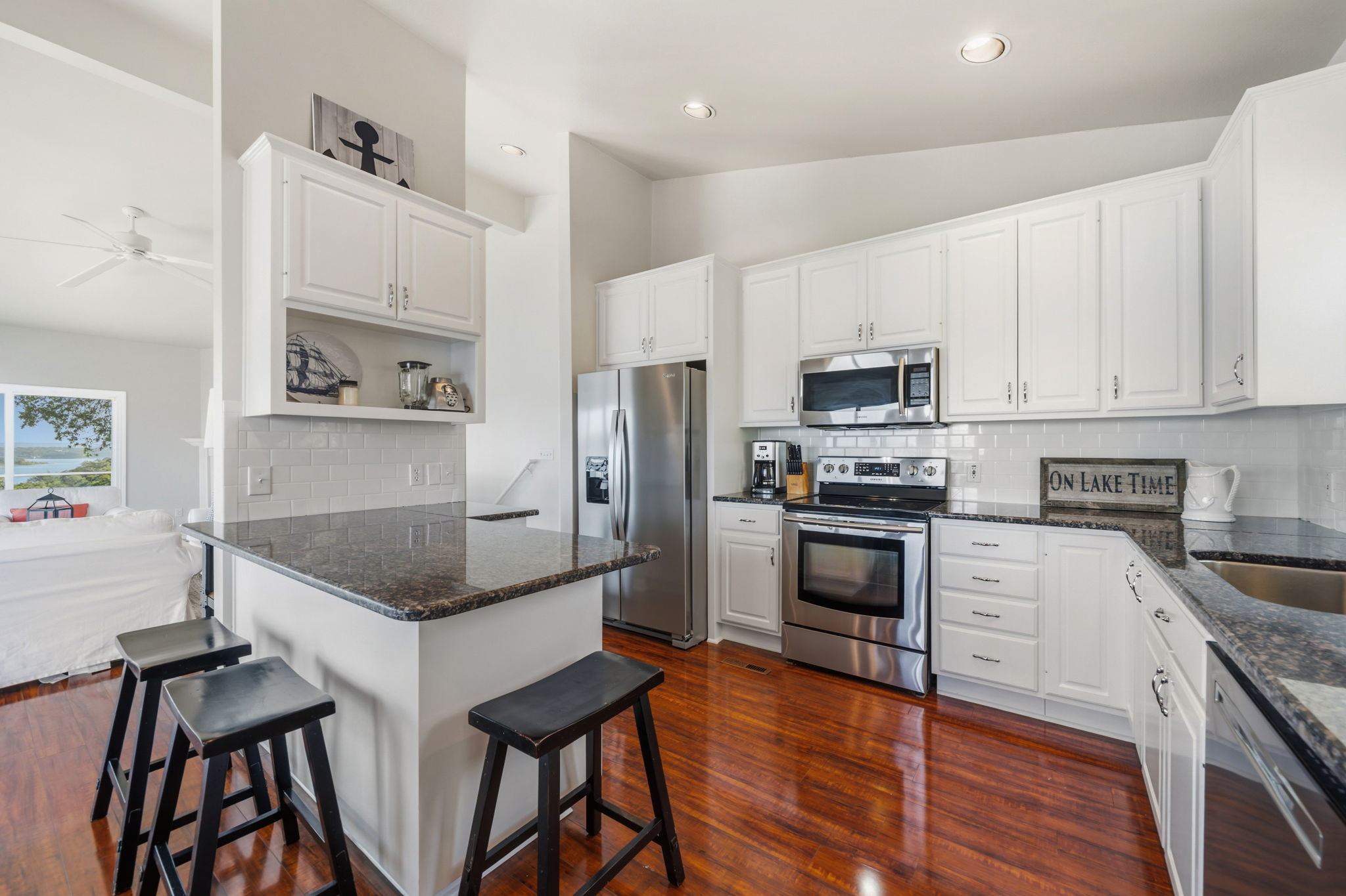 1715 Buffalo Gap Road Austin, TX 78734 - Photo 11 of 18 Polished hardwood floors and dark stone counters anchor this bright, open-plan kitchen.