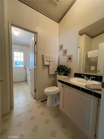 a bathroom with a granite countertop sink a toilet and a mirror