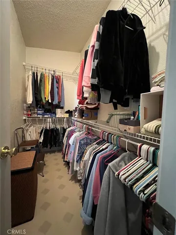 a view of walk in closet with clothes and shoes