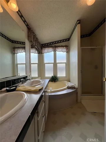 a bathroom with a granite countertop sink and a bathtub