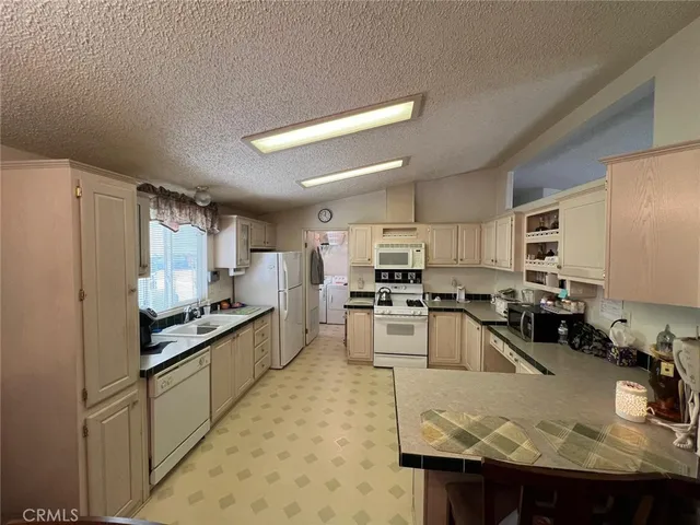 a large kitchen with kitchen island granite countertop a large counter top stainless steel appliances and cabinets