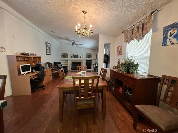 a living room with furniture kitchen view and a chandelier