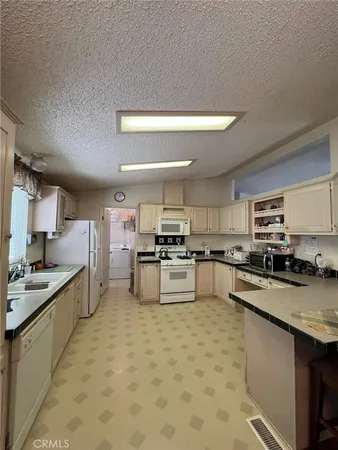a kitchen with stainless steel appliances granite countertop a sink stove oven and white cabinets