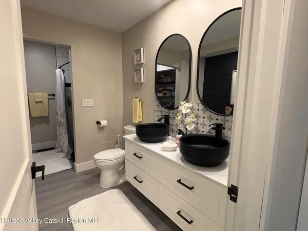 a bathroom with a toilet sink and mirror