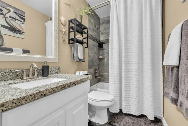 a bathroom with a granite countertop sink toilet and shower