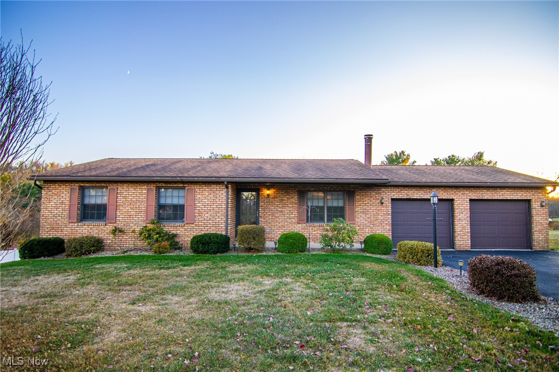 Single story home with a garage and a front yard