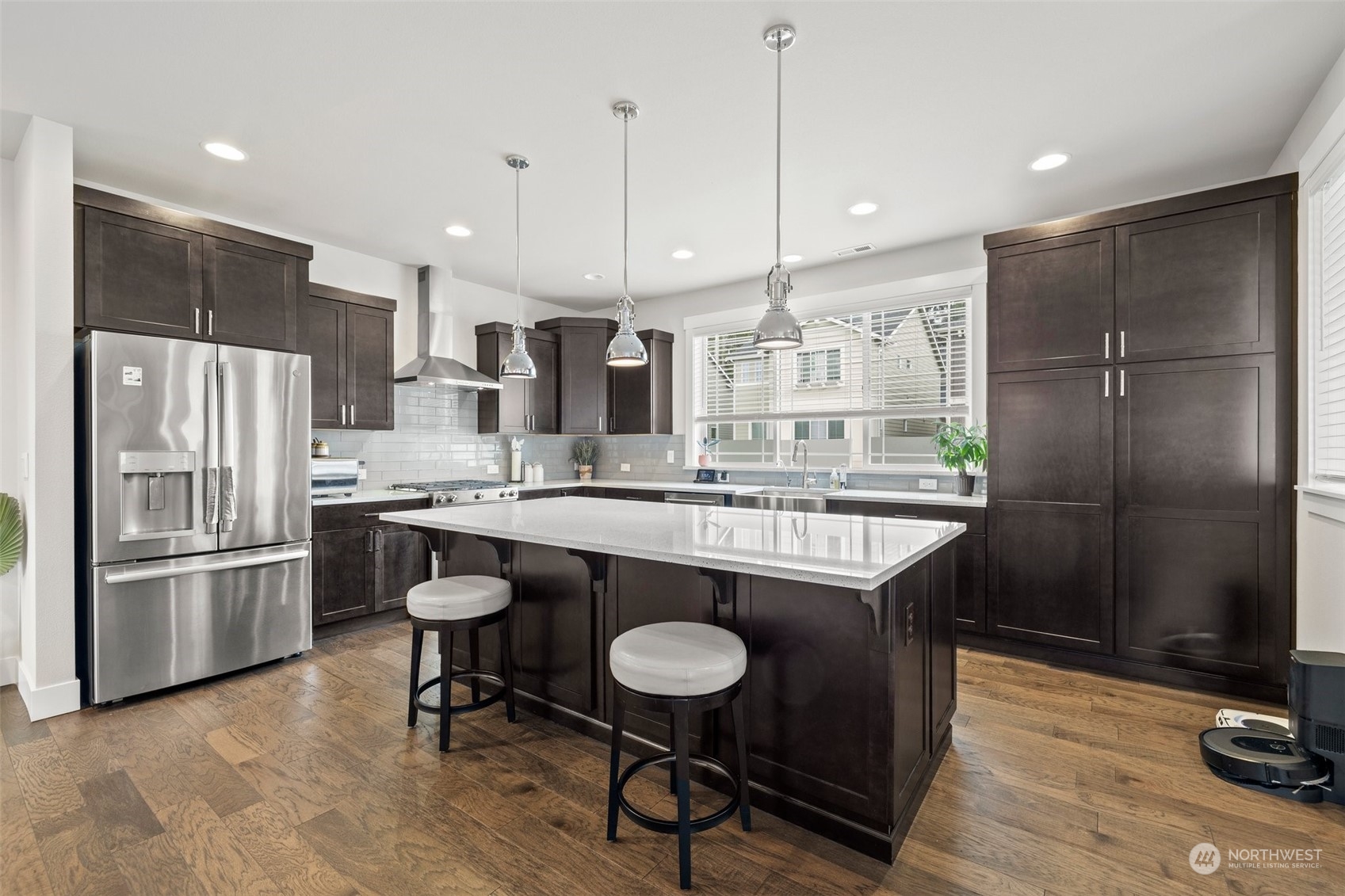 19732 Meridian Place West Bothell, WA 98012 - Photo 8 of 20 a kitchen with stainless steel appliances granite countertop a table chairs wooden floors and kitchen view