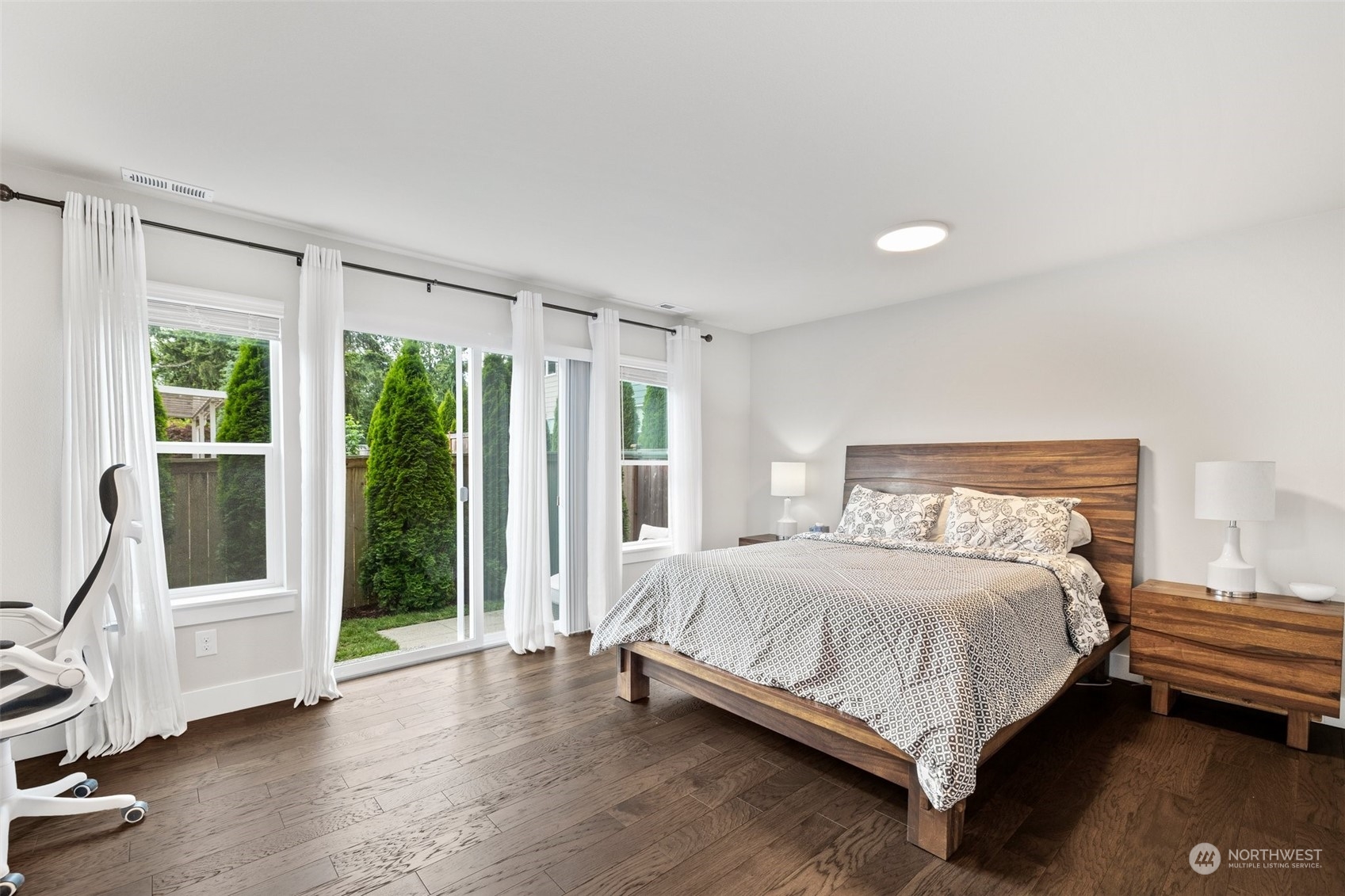 19732 Meridian Place West Bothell, WA 98012 - Photo 10 of 20 a bedroom with a bed wooden floor and windows