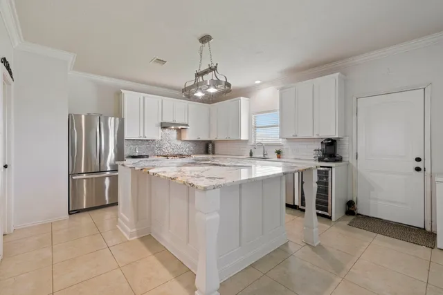 a kitchen with kitchen island granite countertop a refrigerator oven a sink and dishwasher