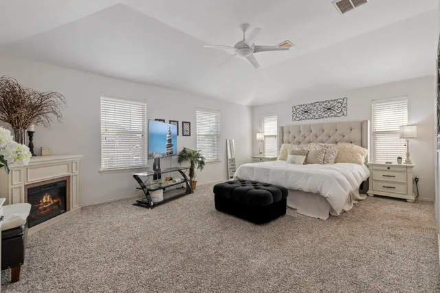 a spacious bedroom with a bed a couch and a fireplace