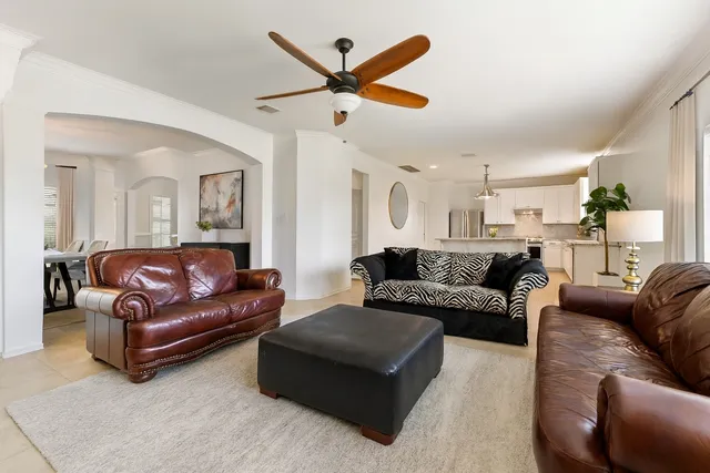 a living room with furniture and a ceiling fan