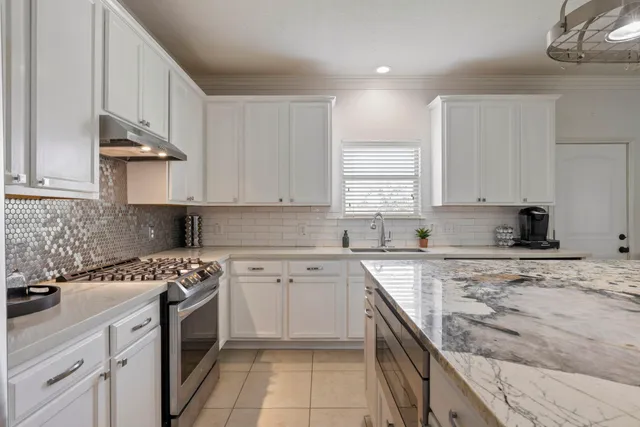 a kitchen with a sink stove top oven and cabinets