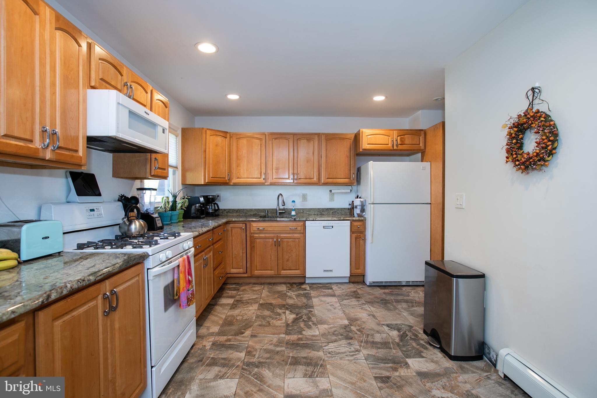 2112 Klockner Road Hamilton, NJ 08690 - Photo 14 of 40 a kitchen with kitchen island granite countertop a refrigerator a sink a stove a microwave and cabinets