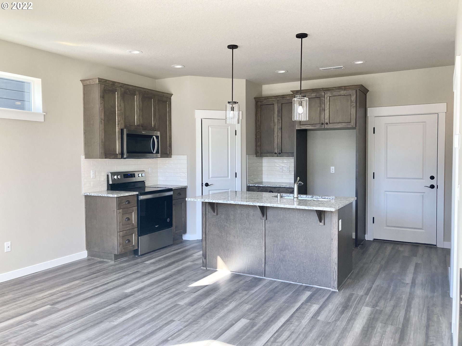 7250 South Ridge Way Ridgefield, WA 98642 - Photo 2 of 16 a kitchen with stainless steel appliances a refrigerator and a stove top oven