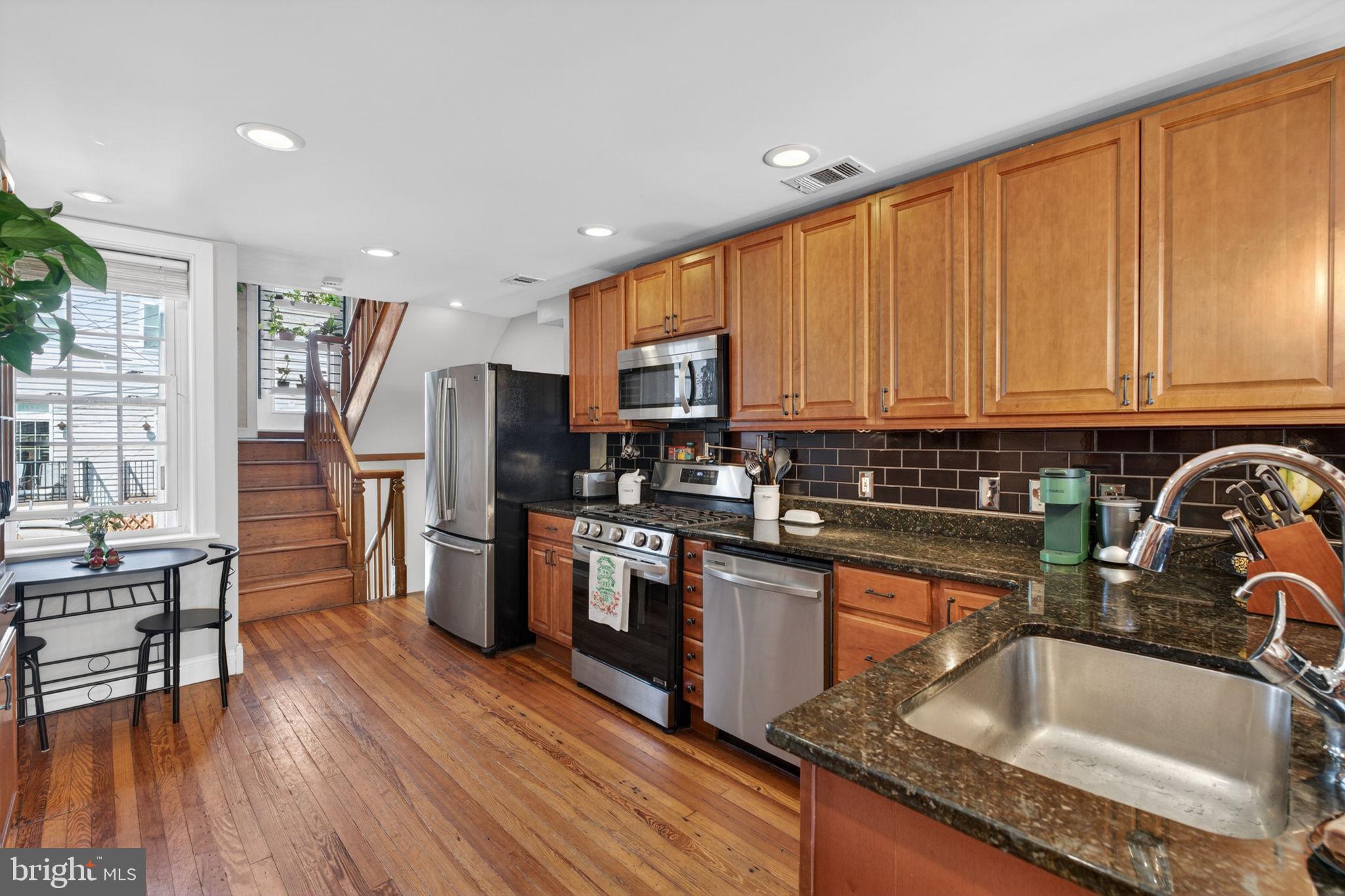 18 South Washington Street Baltimore, MD 21231 - Photo 11 of 57 a kitchen with stainless steel appliances granite countertop a refrigerator sink and cabinets