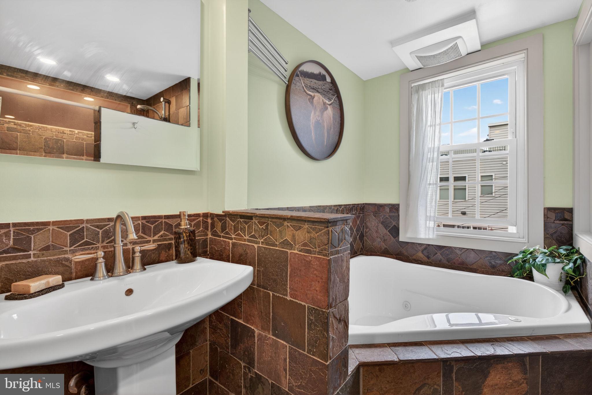 18 South Washington Street Baltimore, MD 21231 - Photo 25 of 57 a bathroom with a bathtub a sink and a mirror