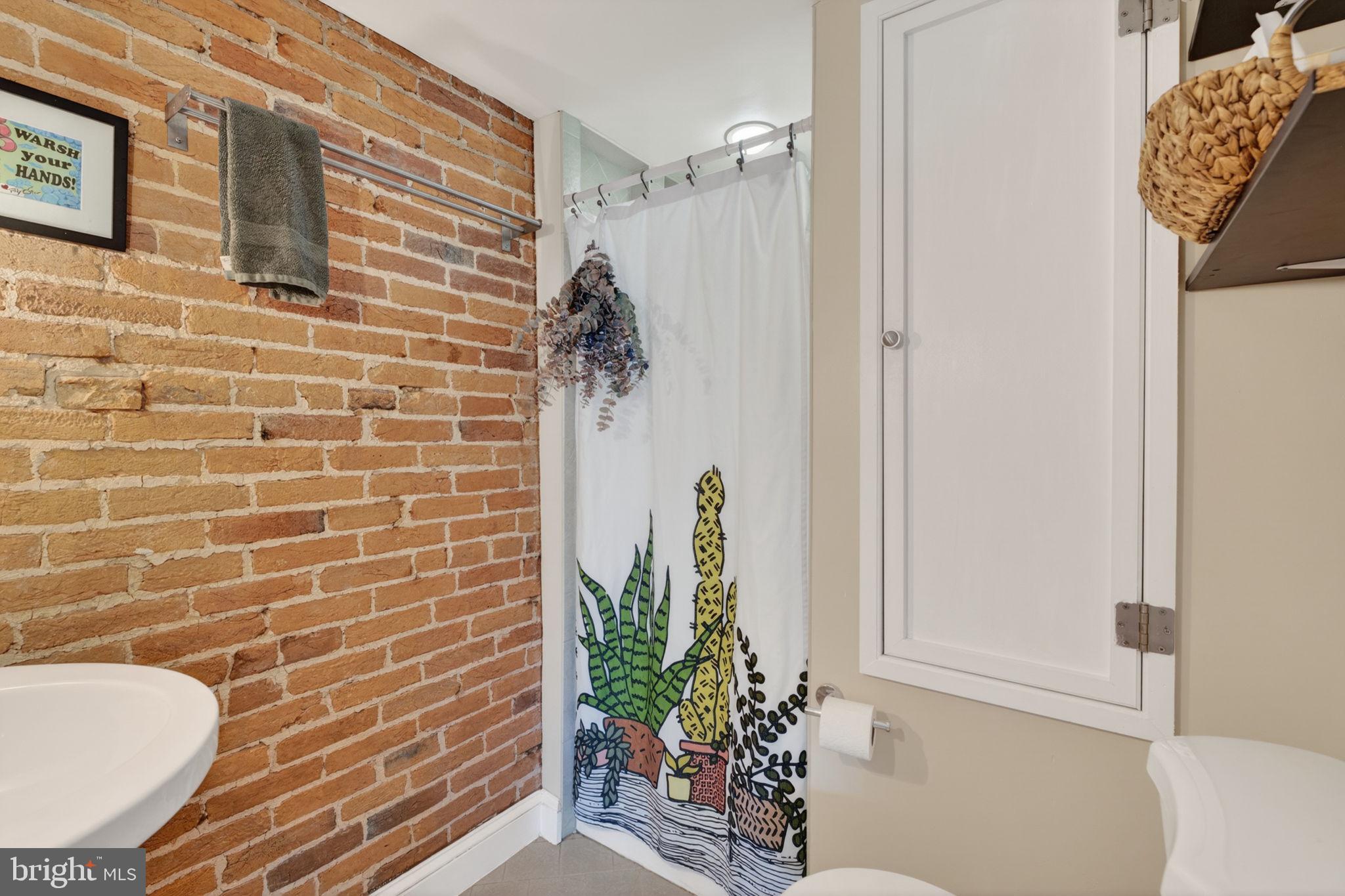 18 South Washington Street Baltimore, MD 21231 - Photo 36 of 57 a bathroom with a granite countertop shower a mirror and a sink