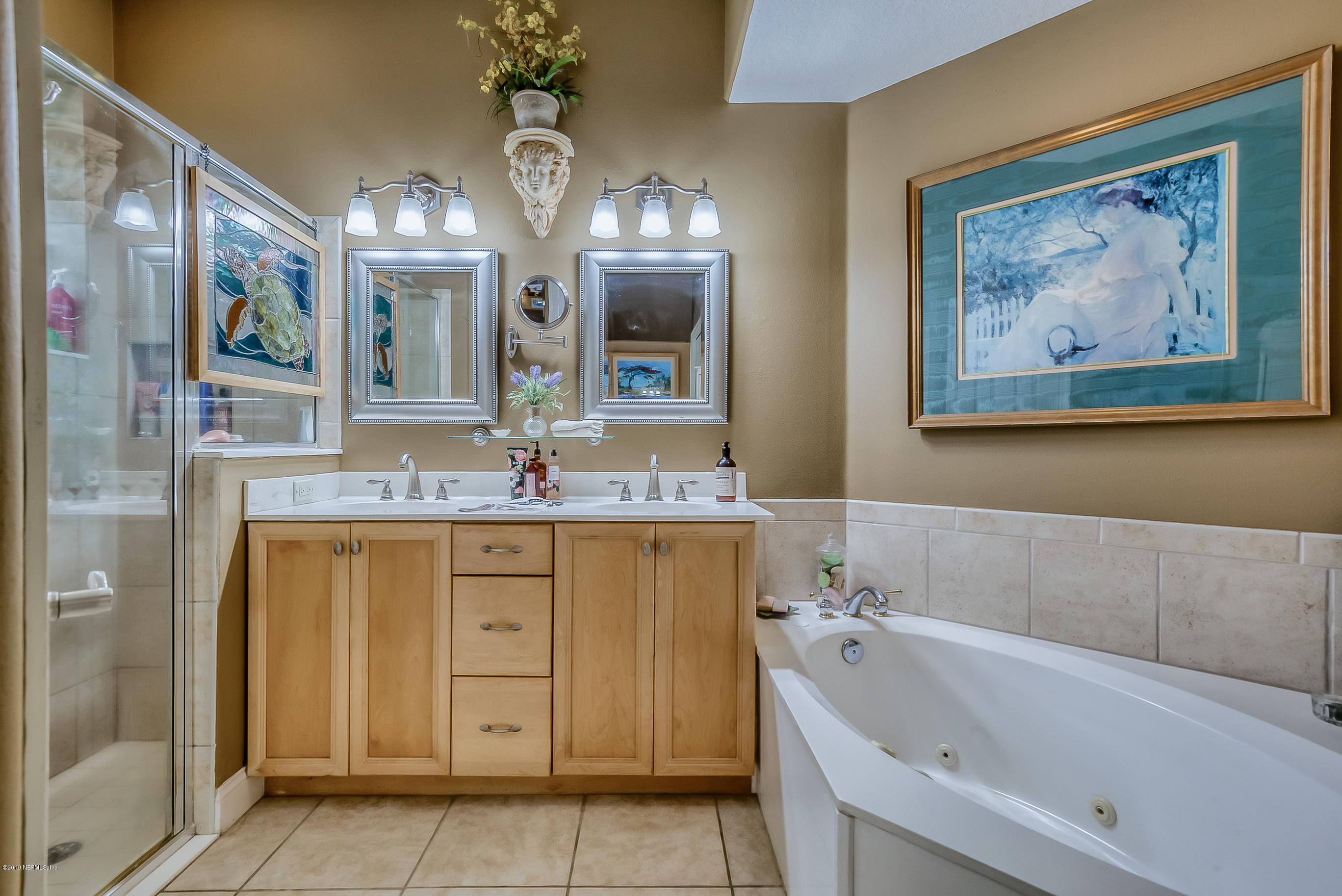 200 Cedar Ridge Circle St. Augustine, FL 32080 - Photo 19 of 41 a bathroom with a tub a double vanity sink and a mirror