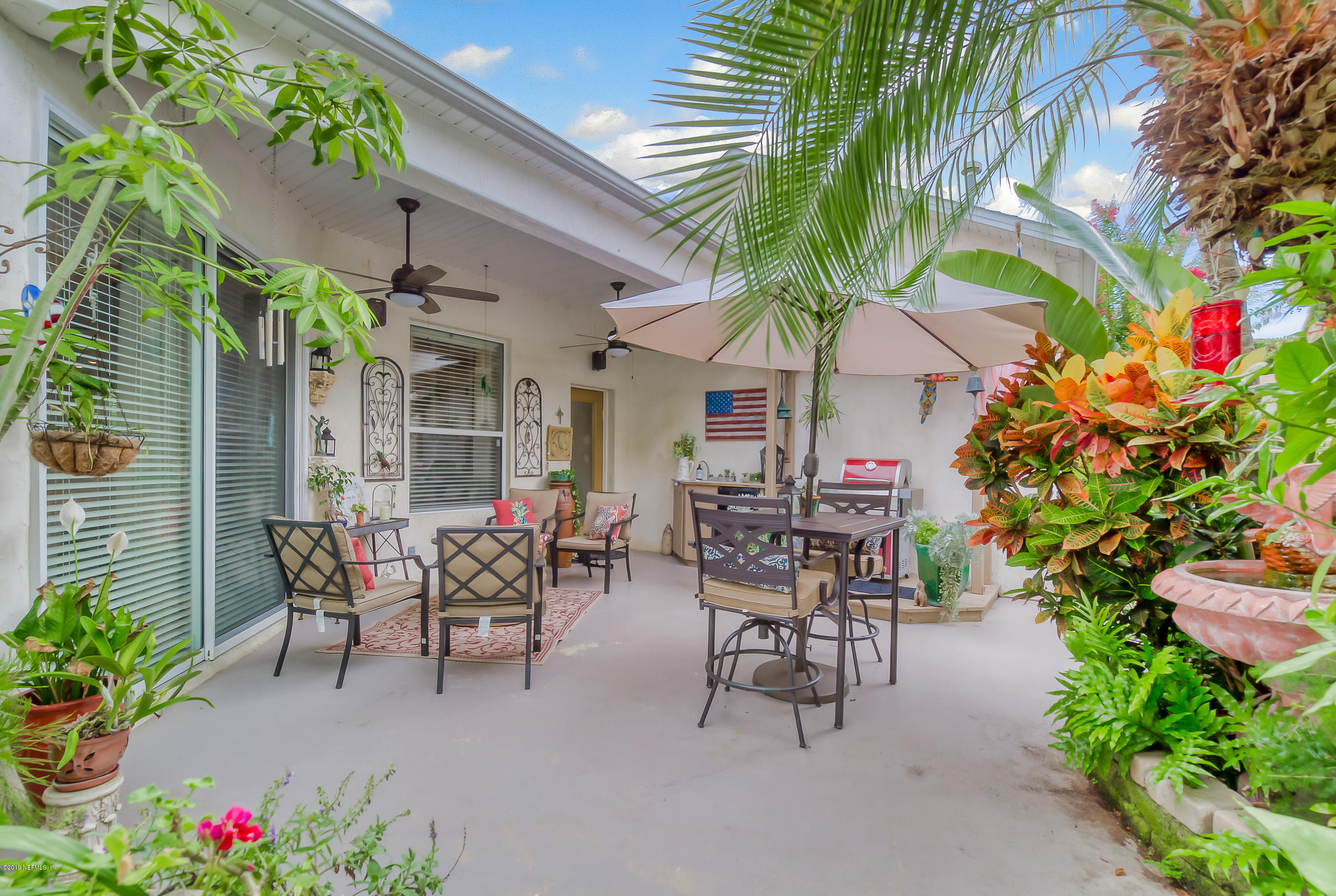 200 Cedar Ridge Circle St. Augustine, FL 32080 - Photo 30 of 41 a view of a patio with table and chairs potted plants and a fountain