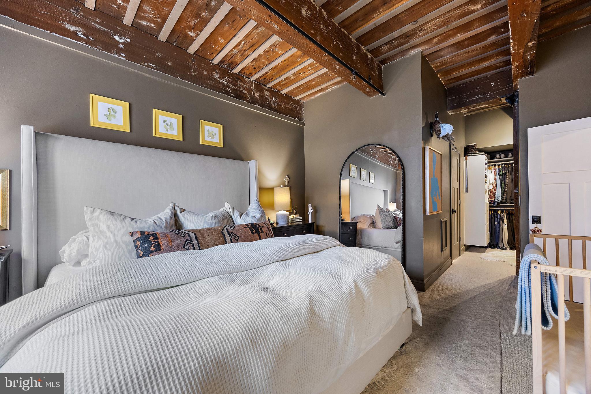 49 Bancroft Mills Road, Unit 2B Wilmington, DE 19806 - Photo 11 of 18 a bedroom with a large bed with a large mirror