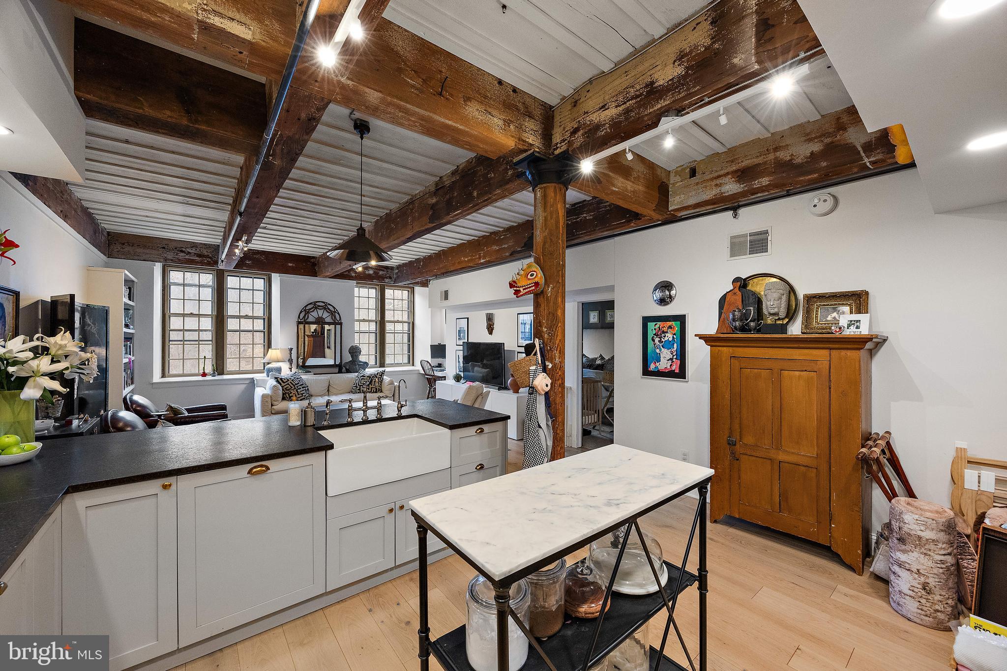 49 Bancroft Mills Road, Unit 2B Wilmington, DE 19806 - Photo 4 of 18 a kitchen with sink a refrigerator and chairs
